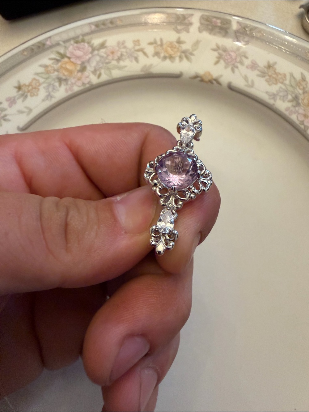 Platinum plated elegant brooch with a large fancy faceted genuine amathyst